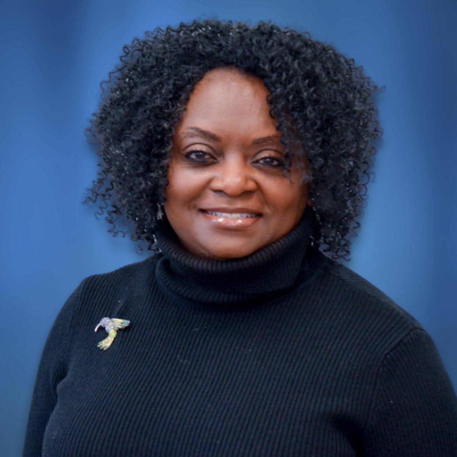 Marie Edwards headshot on blue background.