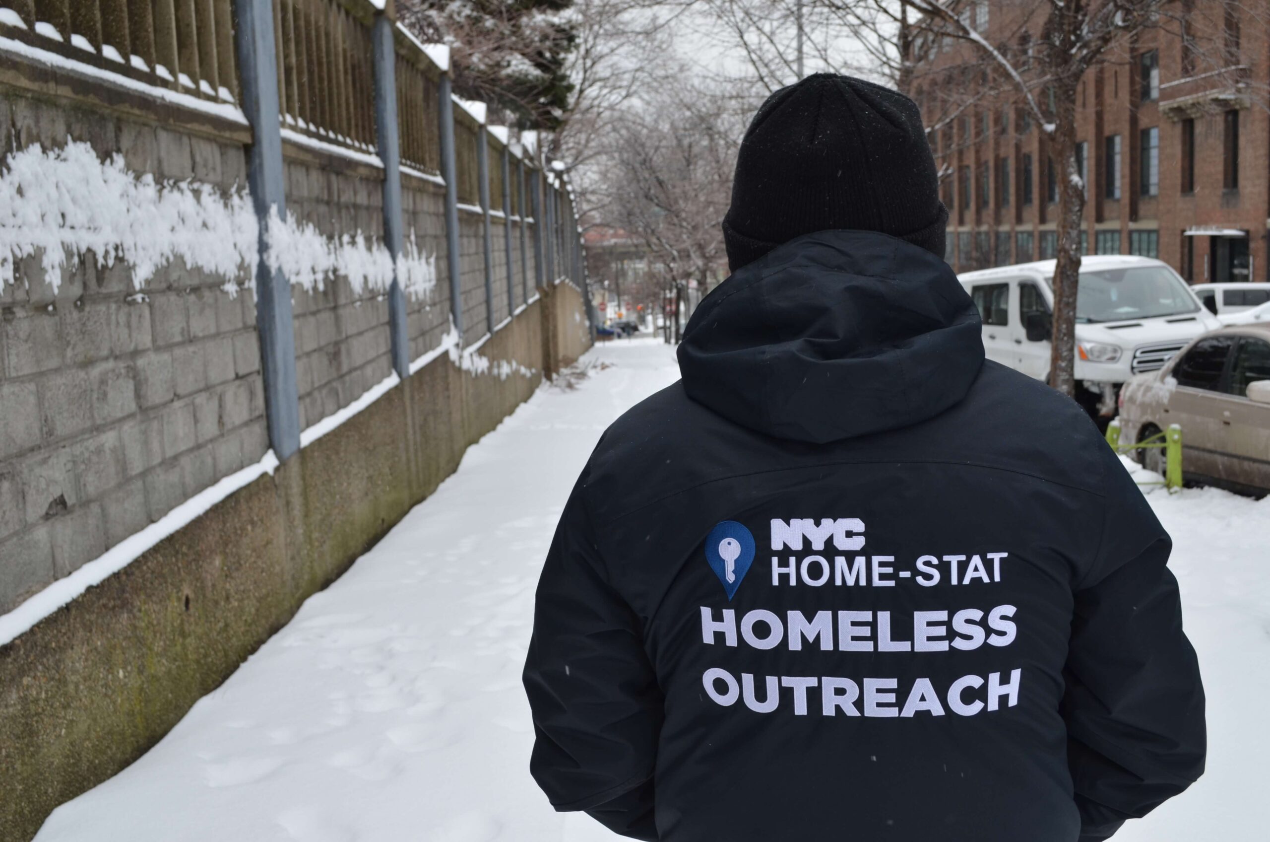 A member of the BronxWorks Homeless Outreach Team walks through the Bronx, facing away from the camera.