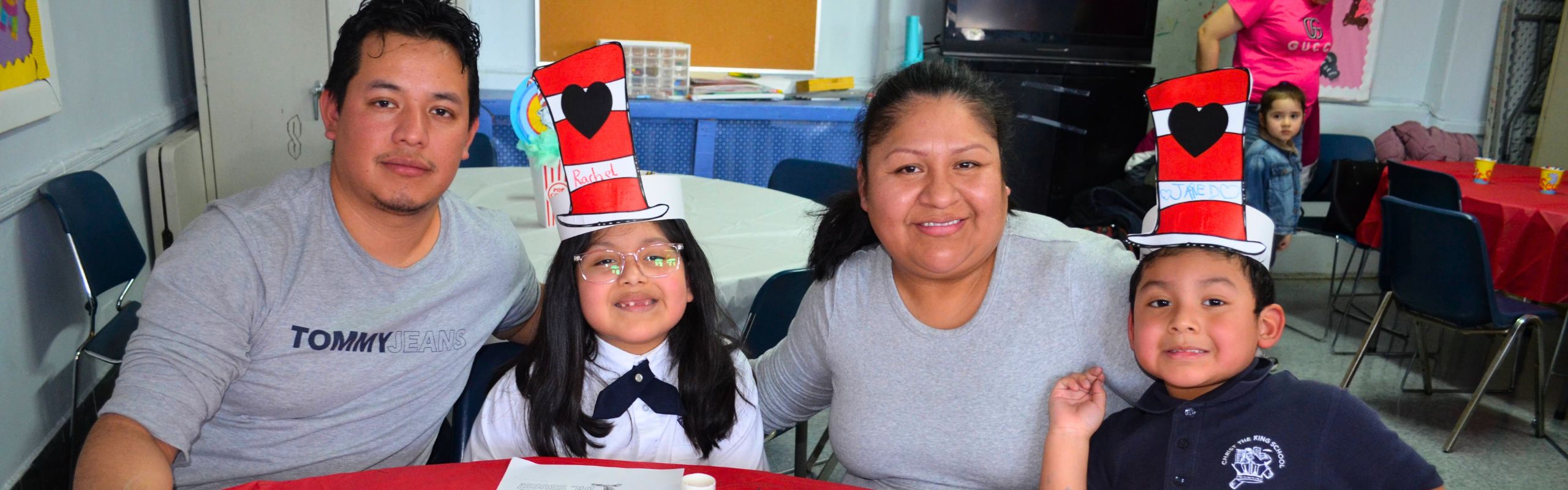 A family all sits together. The children are wearing hats that look like the Cat in The Hat.