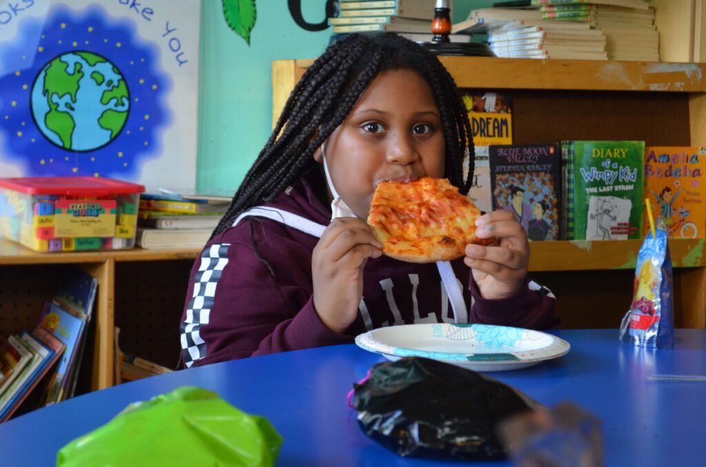 A child enjoys a slice of pizza.