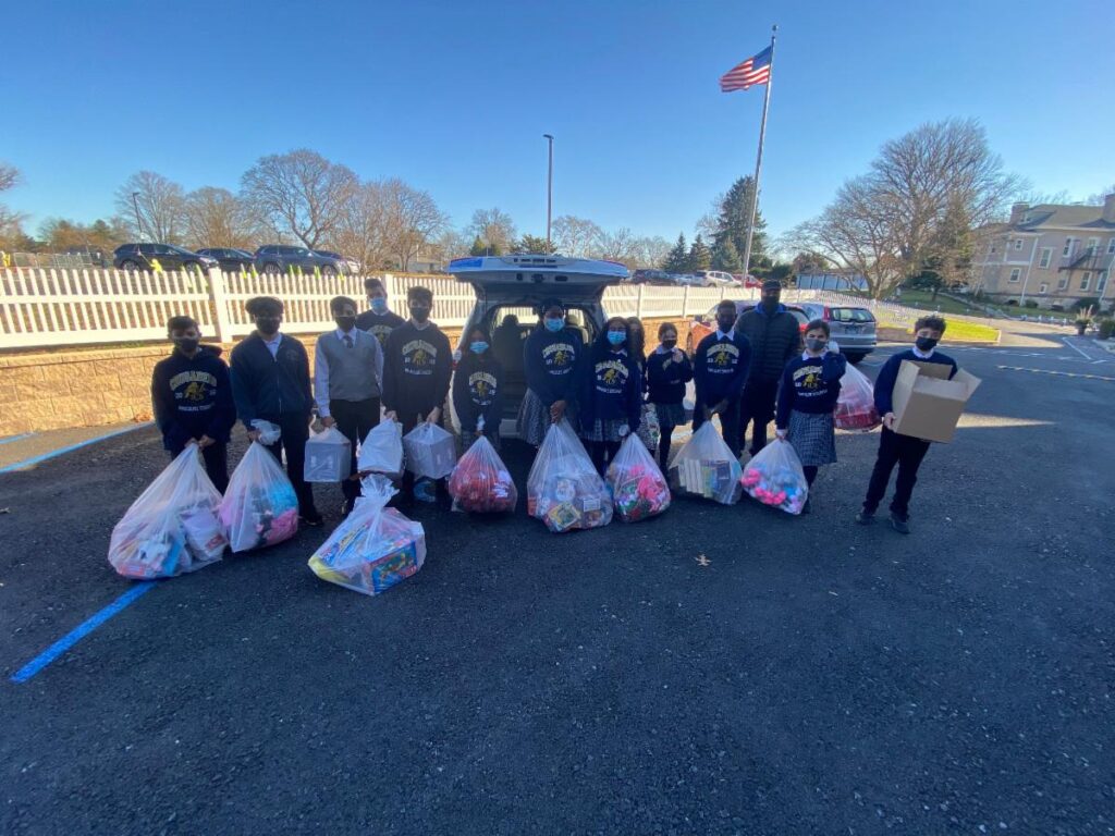 Students from the Immaculate Conception School in Tuckahoe, NY pose with bags of gifts for BronxWorks families.