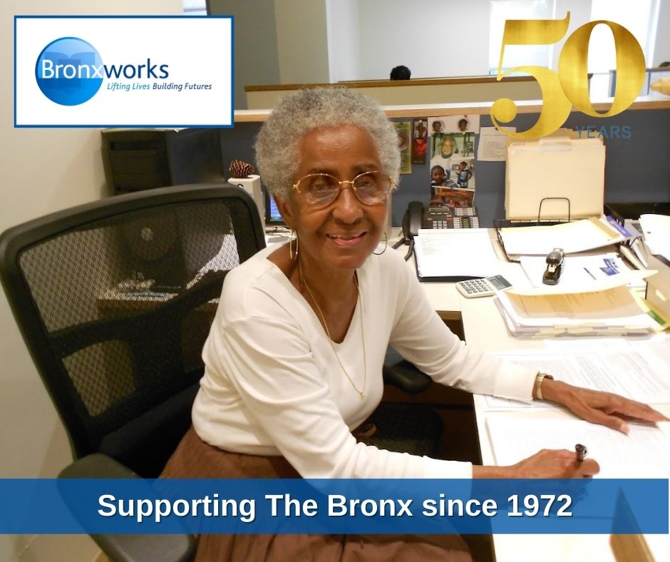 A woman sitting at a desk. There are two graphics added, one is the BronxWorks logo and one is a graphic that says "50 Years". There is text at the bottom that says "Supporting the Bronx since 1972"