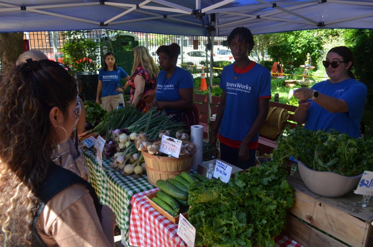 BronxWorks STAFF standing at the Mott Haven Farm Stand with clients