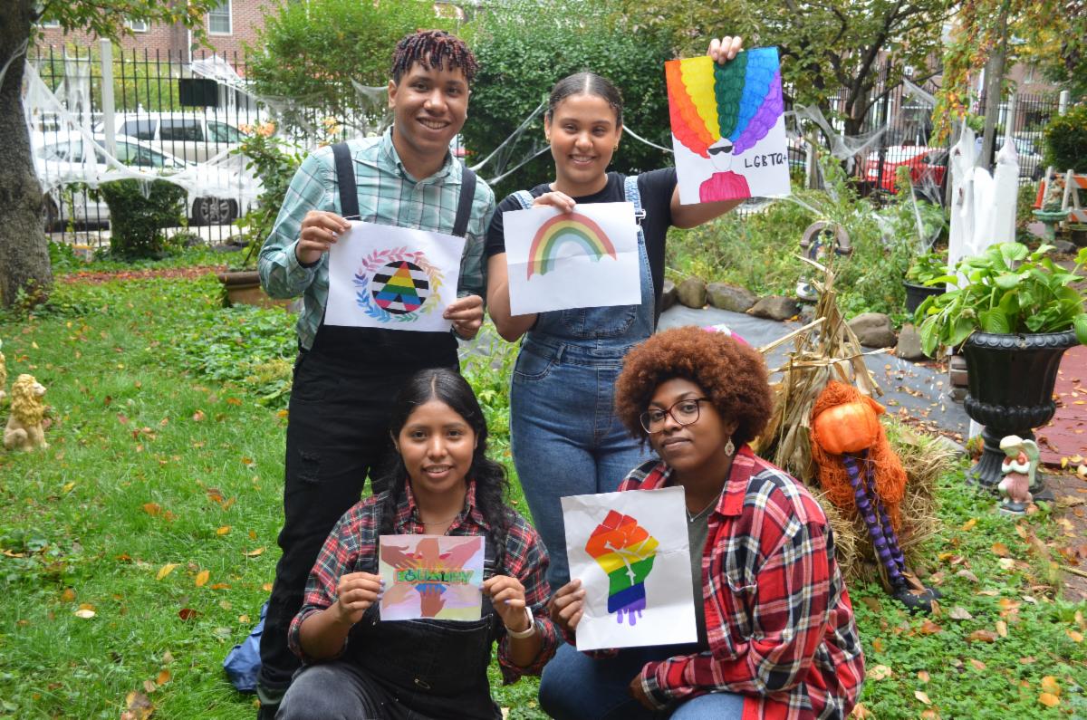 Members of the BronxWorks LGBTQ+ Committee hold signs celebrating Pride.
