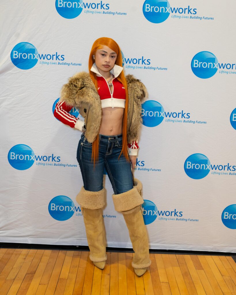 Rapper Ice Spice poses in front of a BronxWorks step & repeat