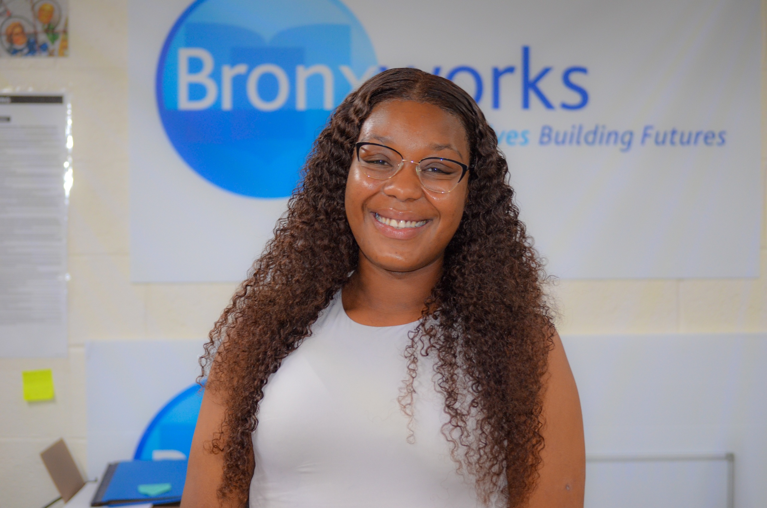 Headshot of Alaysia Fulton-Hodo in front of a BronxWorks sign.